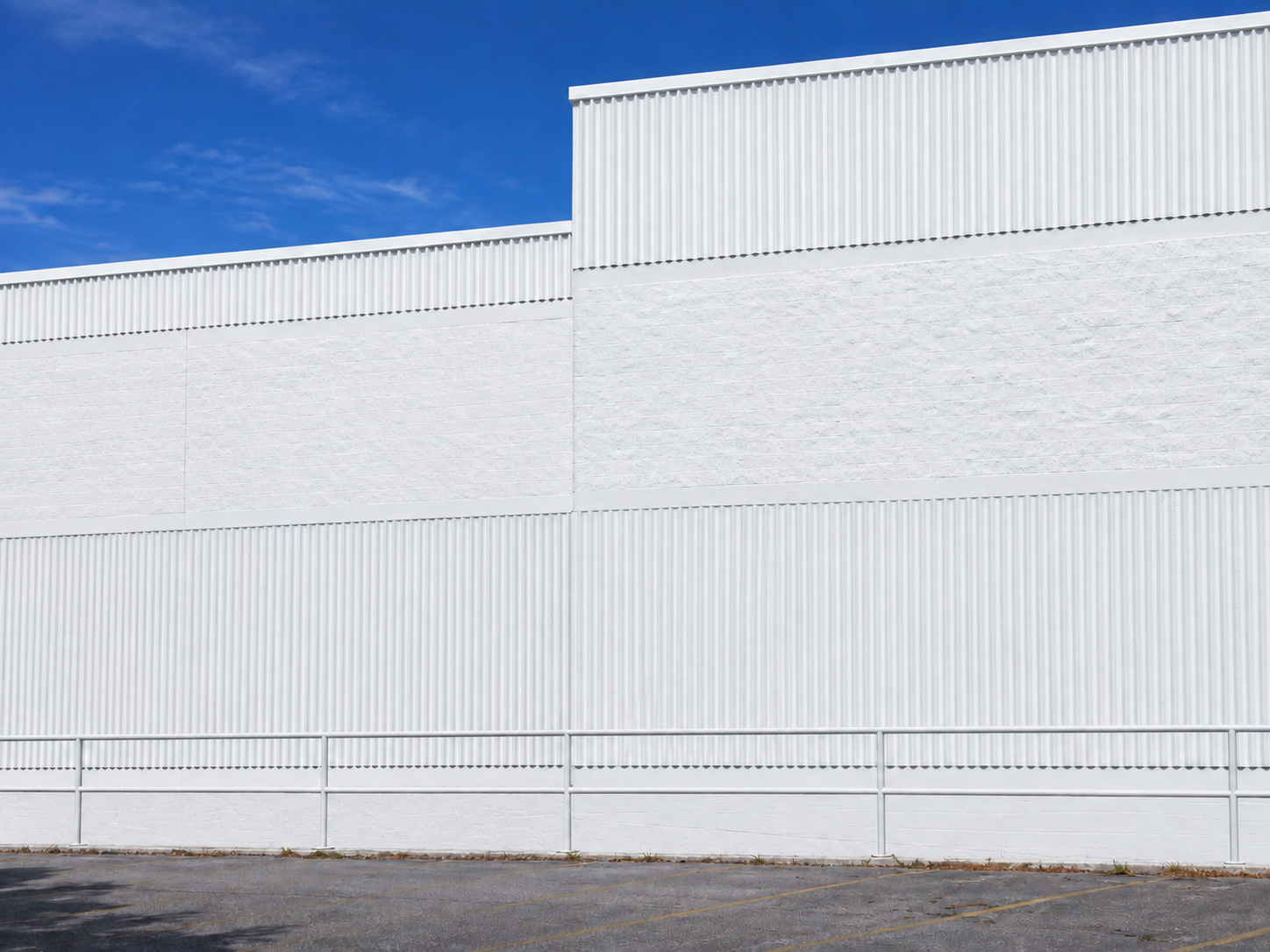 The same Port St. Lucie commercial industrial facade after all exterior surfaces were painted uniformly white and the work area was cleaned